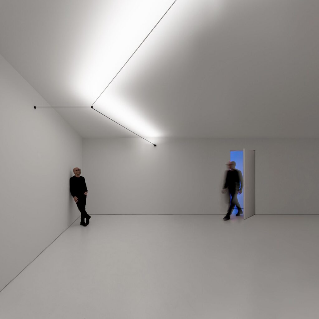 Stanza bianca con le linee di luce Davide Groppi Utopia a soffitto e due persone