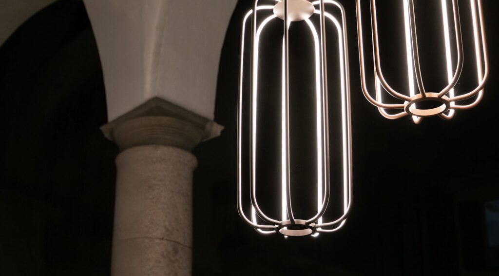 Sospensioni Egoluce Cavea con la gabbia di luce in metallo sotto un porticato