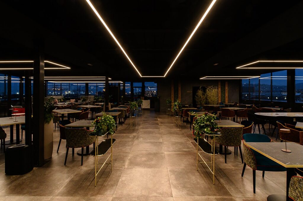 Ristorante con le linee di luce Egoluce Zeppelin a soffitto