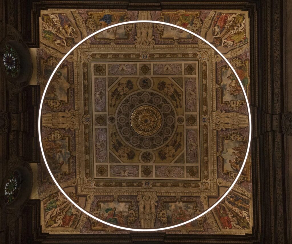 Anello di luce Faro Barcelona sospeso sotto un soffitto affrescato in un palazzo storico