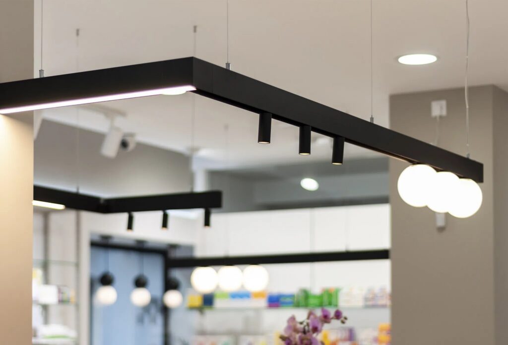 Farmacia illuminata con il binario magnetico Faro Barcelona Neso a soffitto