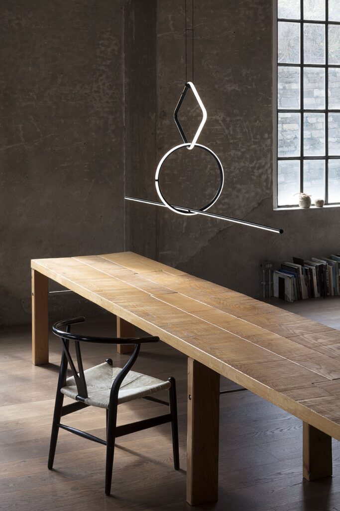 Sospensione Flos Arrangements con gli anelli sopra un tavolo lungo in legno