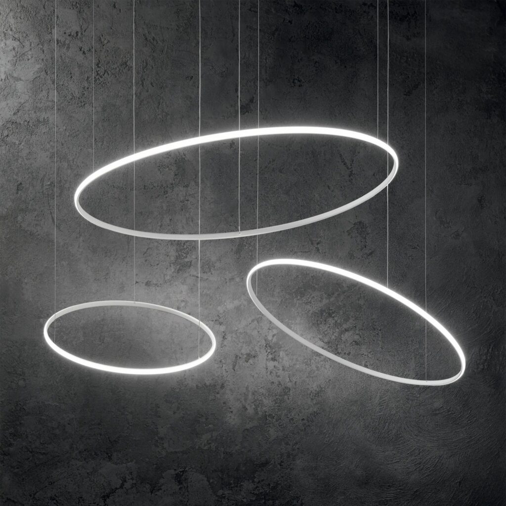 Tre anelli di luce Ideal Lux Hulahoop inclinati su fondo scuro