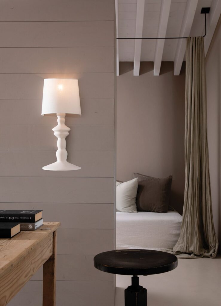 Lampada da tavolo Karman Alì e Babà in ceramica bianca su un comodino