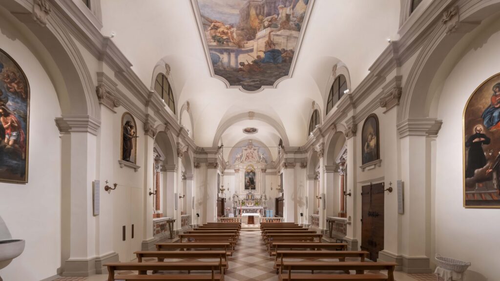 Navata di una chiesa con gli affreschi illuminati dagli apparecchi Linea Light