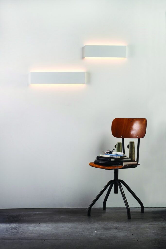 Due applique Lip Lighting Double a parete sopra una sedia da studio