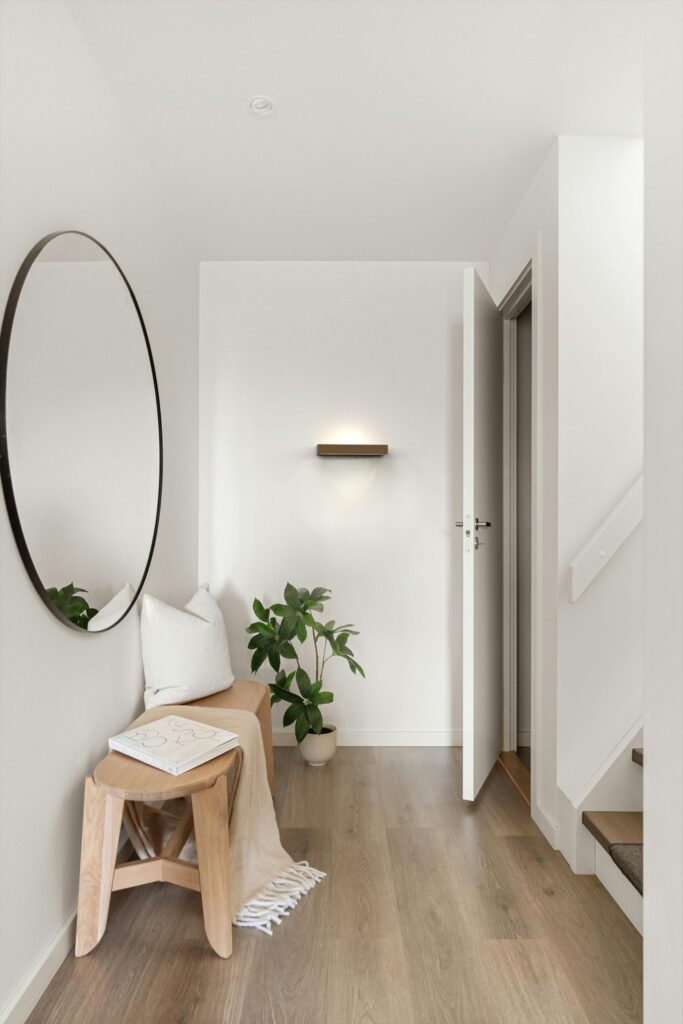 Ingresso con la mensola di luce Lip Lighting Shelf sotto uno specchio tondo