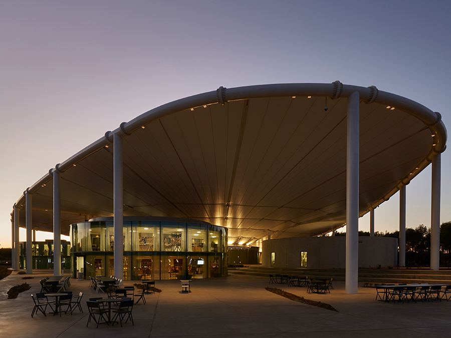 Edificio con la copertura a vela illuminato dagli apparecchi Luce&Light Siri, al tramonto