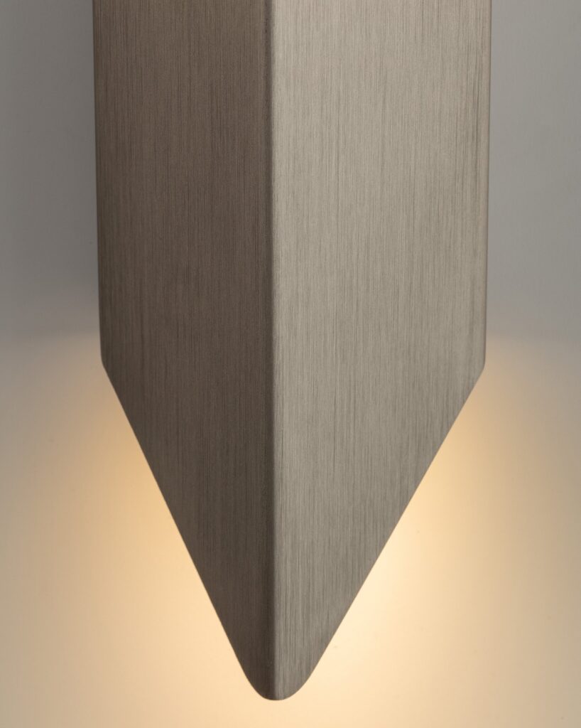 Applique Modular Chival in bronzo vista da vicino, con la luce che esce sotto