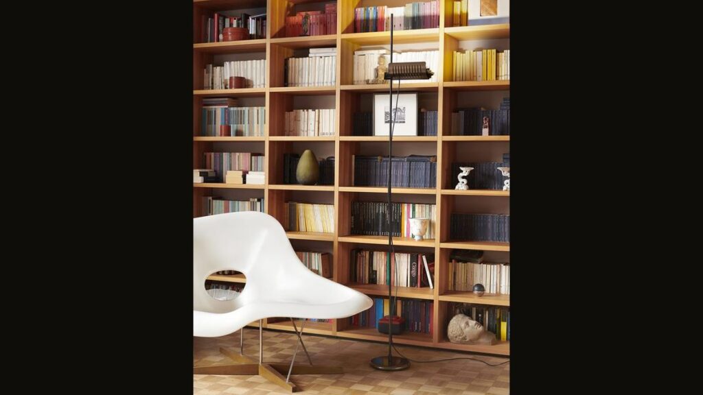 Lampada da terra Oluce Colombo 626 davanti a una libreria