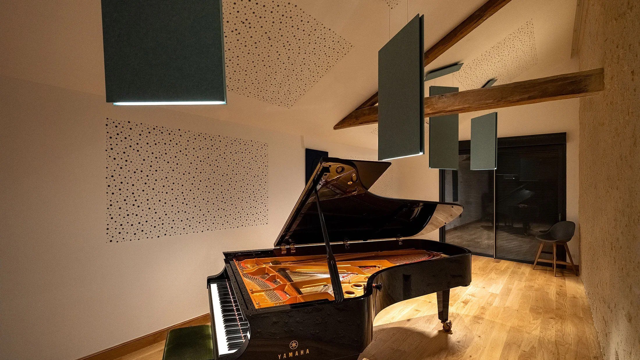 Sala prove con il pianoforte a coda e gli apparecchi acustici Prolicht a soffitto: la stessa scena al buio e con la luce accesa