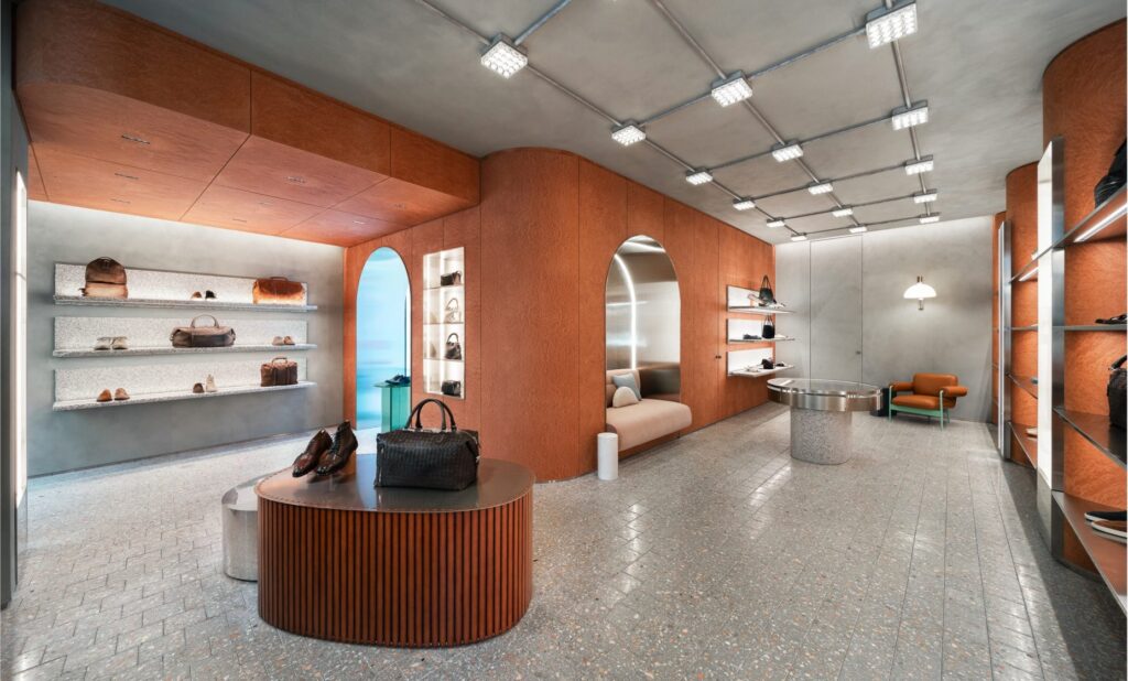 Negozio Officine Creative con gli scaffali in legno e la luce Reggiani