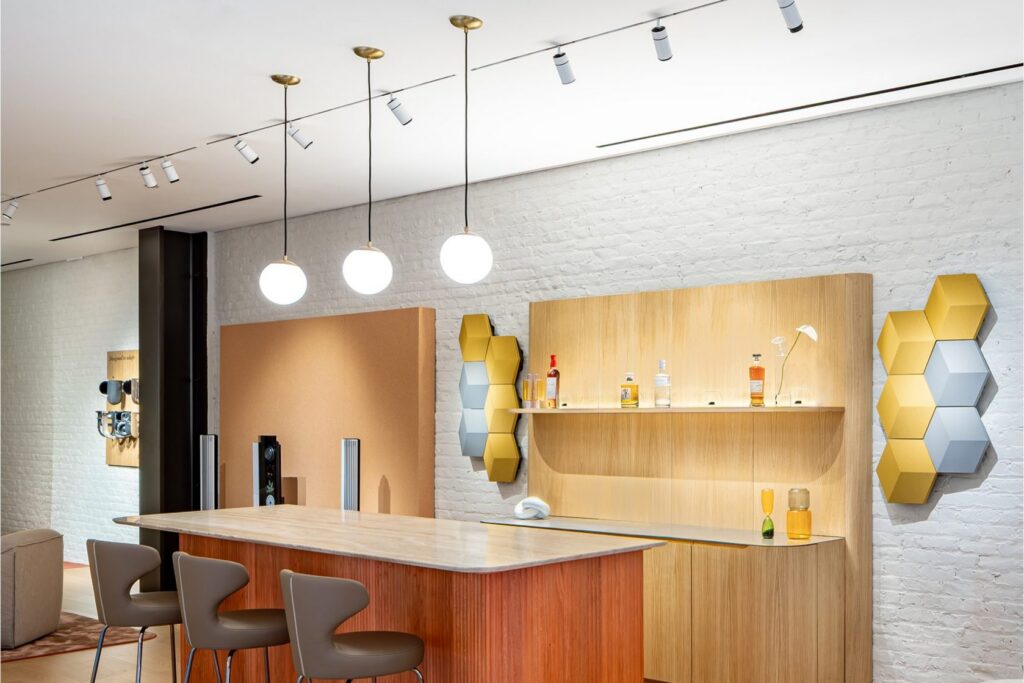 Negozio Bang & Olufsen con le pareti in legno illuminate dai proiettori Reggiani Yori