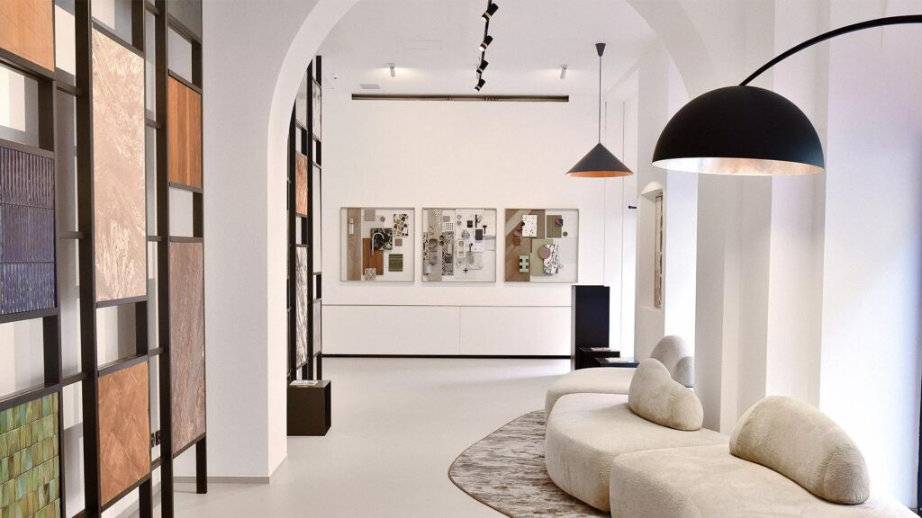 Ingresso dello showroom Zava a Milano con la lampada ad arco nera e i campioni di materiali alle pareti